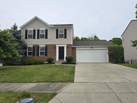 A house with a grey roof and a white garage door.